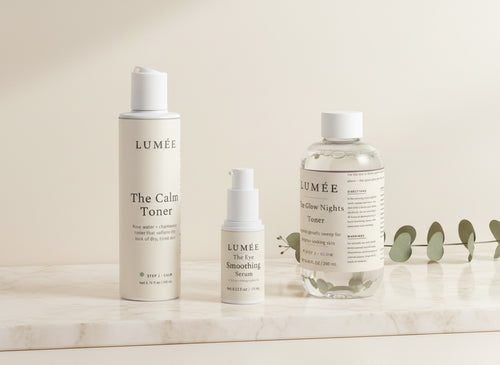 The Fresh Face Ritual — the three bottles together: Step 1 The Calm Toner, Step 2 The Eye Smoothing Serum, Step 3 The Glow Nights Toner, on warm marble in morning light
