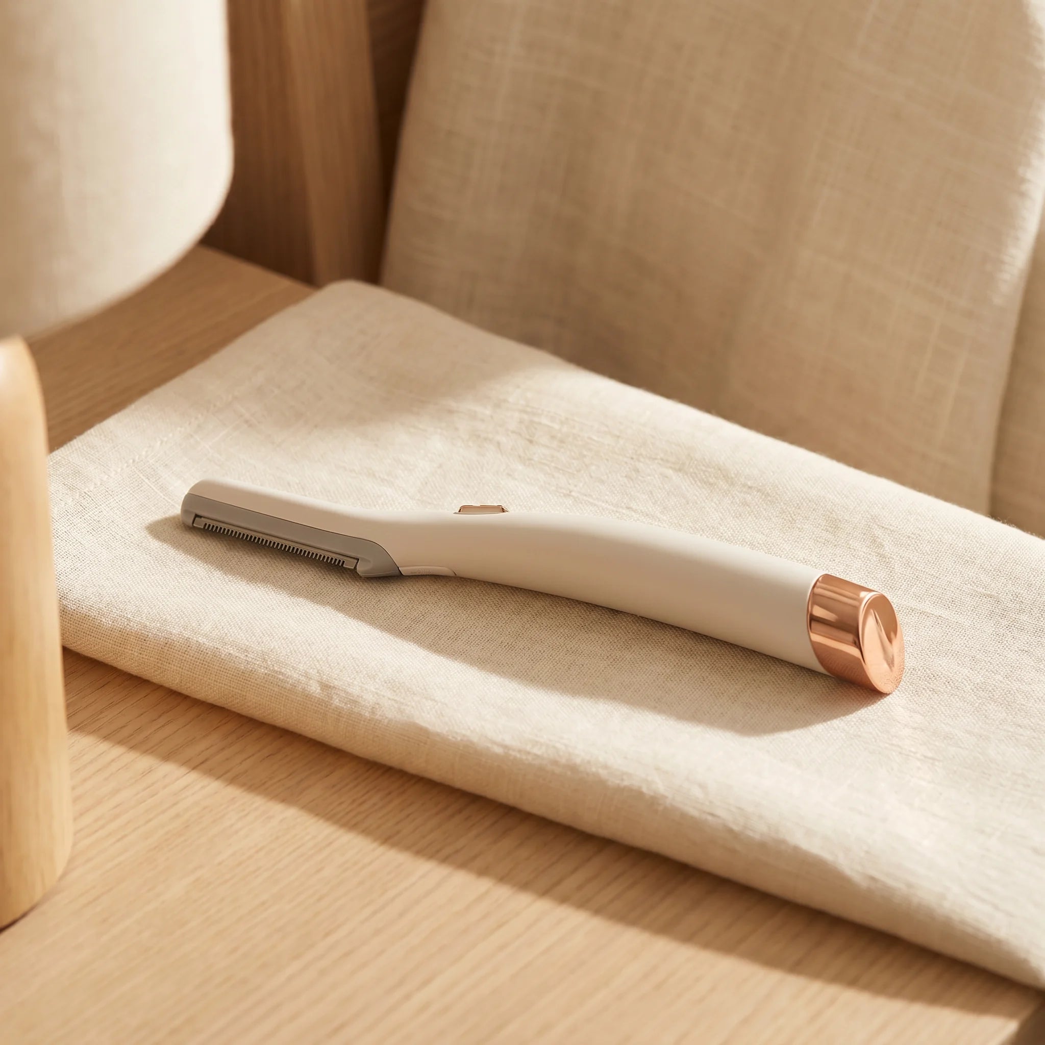 Lumée LED facial trimmer, cream and rose-gold, on the vanity