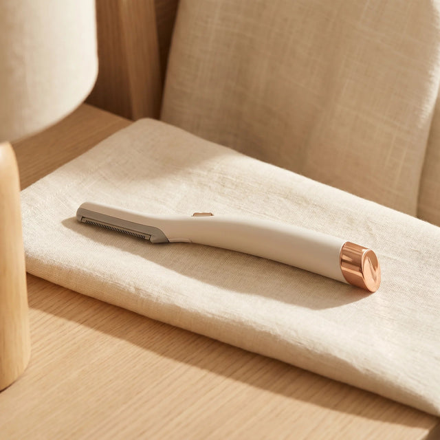 Lumée LED facial trimmer, cream and rose-gold, on the vanity
